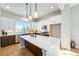 Modern kitchen boasts white cabinets, stainless steel appliances, and a large island with ample counter space at 888 S Valentia St # 104, Denver, CO 80247