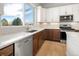 Bright kitchen featuring stainless appliances, mixed cabinetry, quartz counters, and oversized window at 888 S Valentia St # 104, Denver, CO 80247