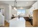 Stylish kitchen features white cabinets, stainless steel appliances, a large island and wood floors at 888 S Valentia St # 104, Denver, CO 80247