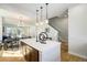 Open floor plan with bright kitchen, oversized island, and view to dining and staircase at 888 S Valentia St # 104, Denver, CO 80247