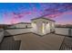 Roof deck view showing the rooftop architecture against a vibrant sunset sky with pink and purple clouds at 888 S Valentia St # 104, Denver, CO 80247