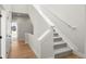 Bright stairway features gray carpeted steps, white walls, and access to another room with light wood floors at 888 S Valentia St # 104, Denver, CO 80247
