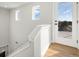 Bright stairway with wood floors leads to a door and railing with natural light filling the space at 888 S Valentia St # 104, Denver, CO 80247