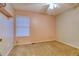 A simple bedroom with plush carpet, a ceiling fan, and a window at 10320 E Jewell Ave # 63, Aurora, CO 80247