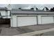Attached one car garage with white door and adjacent parking in front of the home at 10320 E Jewell Ave # 63, Aurora, CO 80247