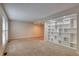 Living room featuring neutral walls and carpet, a large window and built-in shelving at 10320 E Jewell Ave # 63, Aurora, CO 80247