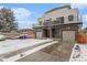 Modern duplex with gray siding, attached garages, and snowy driveway at 1449 Ivy St, Denver, CO 80220