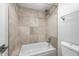 Tiled shower-over-tub with neutral colors and bright white porcelain fixtures and showerhead at 7665 E Eastman Ave # 301A, Denver, CO 80231