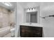 Bathroom with shower over tub, vanity sink with dark wood cabinets and large mirror at 7665 E Eastman Ave # 301A, Denver, CO 80231