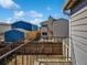 Backyard view from the balcony showcasing a fenced yard and neighboring homes under a blue sky at 11813 Grant St, Northglenn, CO 80233