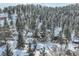 Aerial view of a secluded home nestled among snow-covered trees in a serene, mountainous setting at 26288 S End Rd, Kittredge, CO 80457