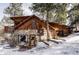 Charming stone and wood home with snow covered yard surrounded by trees at 26288 S End Rd, Kittredge, CO 80457