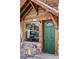 Inviting entrance featuring a green front door, large window, stone accents, and a charming address plate at 26288 S End Rd, Kittredge, CO 80457