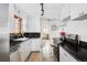 Bright kitchen with white cabinetry, black countertops, and stainless steel appliances at 26288 S End Rd, Kittredge, CO 80457