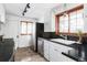 Well-lit kitchen featuring black countertops, stainless steel appliances, and wood-trimmed windows at 26288 S End Rd, Kittredge, CO 80457