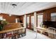 Spacious office featuring wood paneling, white ceiling, multiple work stations, and natural light from patio doors at 26288 S End Rd, Kittredge, CO 80457