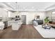 Open concept living area with stainless appliances, hardwood floors, island with bar seating, and modern furnishings at 5360 Allison St # D, Arvada, CO 80002