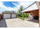 Brick home featuring a covered patio and detached garage for extra parking at 4433 S Washington St, Englewood, CO 80113