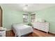 A charming bedroom with a light green wall paint, hardwood floors and classic chandelier at 4433 S Washington St, Englewood, CO 80113