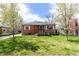 Traditional brick home featuring a welcoming front yard and a classic design with white shutters, creating an inviting atmosphere at 4433 S Washington St, Englewood, CO 80113