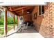 Covered brick patio with a ceiling fan and outdoor dining set, ideal for entertaining at 4433 S Washington St, Englewood, CO 80113