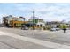 A street with multiple storefronts and restaurants under a partly cloudy sky at 4433 S Washington St, Englewood, CO 80113
