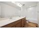 Bathroom with a double sink vanity and a shower with a white-tiled surround at 45952 Gentry Ave, Bennett, CO 80102