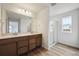 Modern bathroom featuring a double vanity, glass-enclosed shower, and wood-look flooring at 45952 Gentry Ave, Bennett, CO 80102