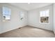 Sunlit bedroom with neutral carpet, white walls and three windows at 45952 Gentry Ave, Bennett, CO 80102