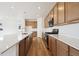 Spacious kitchen featuring stainless steel appliances, wood cabinets and a large island with quartz countertops at 45952 Gentry Ave, Bennett, CO 80102