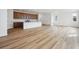 Open-concept living room featuring wood floors, recessed lighting, and seamless flow into the adjacent kitchen area at 45952 Gentry Ave, Bennett, CO 80102