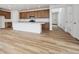 Open-concept living room featuring wood floors, recessed lighting, and seamless flow into the adjacent kitchen area at 45952 Gentry Ave, Bennett, CO 80102
