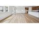 Open-concept living room featuring wood floors, recessed lighting, and seamless flow into the adjacent kitchen area at 45952 Gentry Ave, Bennett, CO 80102