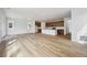 Open-concept living room featuring wood floors, recessed lighting, and seamless flow into the adjacent kitchen area at 45952 Gentry Ave, Bennett, CO 80102