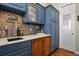Charming butler pantry featuring custom cabinets, granite countertops, and decorative tile backsplash and pantry door at 3973 Palmer Ridge Dr, Parker, CO 80134