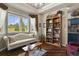 Bright dining room with tray ceilings, large windows, and a cozy library area with custom bookshelf at 3973 Palmer Ridge Dr, Parker, CO 80134