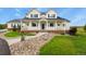 Inviting two-story home featuring a charming front porch, manicured lawn, and stone accents at 3973 Palmer Ridge Dr, Parker, CO 80134