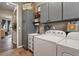 This charming laundry room has built-in gray cabinets and is equipped with a utility sink at 3973 Palmer Ridge Dr, Parker, CO 80134