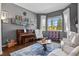 Cozy living room with piano, hardwood floors, and a bright window with outdoor view at 3973 Palmer Ridge Dr, Parker, CO 80134