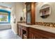 Double vanity main bath with wood cabinetry, elegant mirrors and tilework, and a bright window view at 3973 Palmer Ridge Dr, Parker, CO 80134