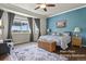 Spacious primary bedroom with large window views, a decorative accent wall, and an elegant rug at 3973 Palmer Ridge Dr, Parker, CO 80134