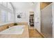 Bathroom showcasing a soaking tub, glass enclosed shower, and walk-in closet at 9025 Rocky Mountain Ln, Parker, CO 80138