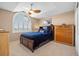 Cozy bedroom with blue bedding, ceiling fan, large window and a closet at 9025 Rocky Mountain Ln, Parker, CO 80138