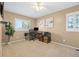 Comfortable bedroom features tan walls, carpet, desk area, and natural lighting at 9025 Rocky Mountain Ln, Parker, CO 80138