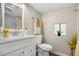 Well-lit bathroom featuring a pristine toilet, vanity, and a window with plants for a fresh ambiance at 13619 Lake Ave, Brighton, CO 80603