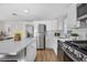 Bright kitchen with white cabinets, stainless steel appliances, and a quartz island with barstool seating at 13619 Lake Ave, Brighton, CO 80603