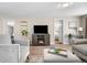 Cozy living room with a fireplace, neutral furniture, and a view into an adjacent bedroom at 13619 Lake Ave, Brighton, CO 80603