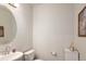 Stylish half-bath featuring a modern vanity, round mirror, and tasteful decor for a clean, updated look at 11228 Bella Vita Dr, Broomfield, CO 80020