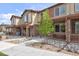 Attractive townhome featuring a stone facade, covered porch, and low maintenance landscaping with neutral color palettes at 11228 Bella Vita Dr, Broomfield, CO 80020