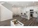 Open-concept living room with modern white kitchen island, hardwood floors, and abundant natural light at 11228 Bella Vita Dr, Broomfield, CO 80020